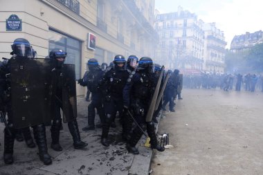 Çevik kuvvet, 1 Mayıs 2023 'te Paris, Fransa' da Fransız emeklilik reform yasasına ve sosyal adalete karşı yapılan seferberlik yürüyüşü sırasında kalabalığı dağıtmak için göz yaşartıcı gaz kullandı..