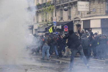 Çevik kuvvet, 1 Mayıs 2023 'te Paris, Fransa' da Fransız emeklilik reform yasasına ve sosyal adalete karşı yapılan seferberlik yürüyüşü sırasında kalabalığı dağıtmak için göz yaşartıcı gaz kullandı..