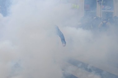 Çevik kuvvet, 1 Mayıs 2023 'te Paris, Fransa' da Fransız emeklilik reform yasasına ve sosyal adalete karşı yapılan seferberlik yürüyüşü sırasında kalabalığı dağıtmak için göz yaşartıcı gaz kullandı..