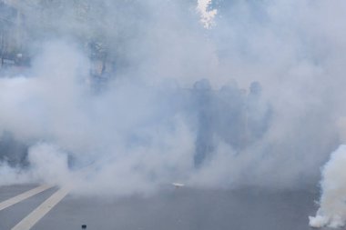 Çevik kuvvet, 1 Mayıs 2023 'te Paris, Fransa' da Fransız emeklilik reform yasasına ve sosyal adalete karşı yapılan seferberlik yürüyüşü sırasında kalabalığı dağıtmak için göz yaşartıcı gaz kullandı..