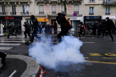 Çevik kuvvet, 1 Mayıs 2023 'te Paris, Fransa' da Fransız emeklilik reform yasasına ve sosyal adalete karşı yapılan seferberlik yürüyüşü sırasında kalabalığı dağıtmak için göz yaşartıcı gaz kullandı..