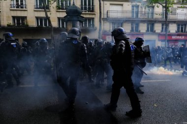 Çevik kuvvet, 1 Mayıs 2023 'te Paris, Fransa' da Fransız emeklilik reform yasasına ve sosyal adalete karşı yapılan seferberlik yürüyüşü sırasında kalabalığı dağıtmak için göz yaşartıcı gaz kullandı..