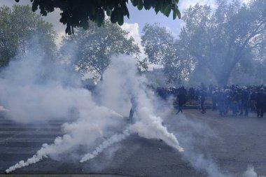 Çevik kuvvet, 1 Mayıs 2023 'te Paris, Fransa' da Fransız emeklilik reform yasasına ve sosyal adalete karşı yapılan seferberlik yürüyüşü sırasında kalabalığı dağıtmak için göz yaşartıcı gaz kullandı..