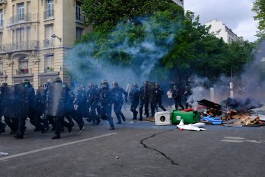 Çevik kuvvet, 1 Mayıs 2023 'te Paris, Fransa' da Fransız emeklilik reform yasasına ve sosyal adalete karşı yapılan seferberlik yürüyüşü sırasında kalabalığı dağıtmak için göz yaşartıcı gaz kullandı..