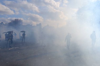 Çevik kuvvet, 1 Mayıs 2023 'te Paris, Fransa' da Fransız emeklilik reform yasasına ve sosyal adalete karşı yapılan seferberlik yürüyüşü sırasında kalabalığı dağıtmak için göz yaşartıcı gaz kullandı..