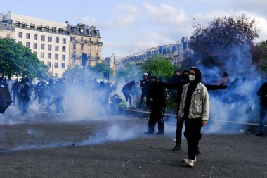 Çevik kuvvet, 1 Mayıs 2023 'te Paris, Fransa' da Fransız emeklilik reform yasasına ve sosyal adalete karşı yapılan seferberlik yürüyüşü sırasında kalabalığı dağıtmak için göz yaşartıcı gaz kullandı..