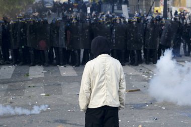 Çevik kuvvet, 1 Mayıs 2023 'te Paris, Fransa' da Fransız emeklilik reform yasasına ve sosyal adalete karşı yapılan seferberlik yürüyüşü sırasında kalabalığı dağıtmak için göz yaşartıcı gaz kullandı..