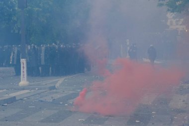 Çevik kuvvet, 1 Mayıs 2023 'te Paris, Fransa' da Fransız emeklilik reform yasasına ve sosyal adalete karşı yapılan seferberlik yürüyüşü sırasında kalabalığı dağıtmak için göz yaşartıcı gaz kullandı..