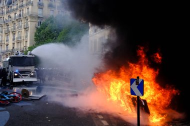 Su Topu, Fransa 'nın 1 Mayıs 2023 tarihli Paris' teki Fransız emeklilik reformuna karşı düzenlenen bir gösteri sırasında yanan scooterlara su püskürttü..