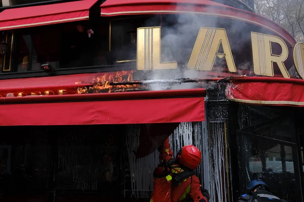 2023年4月6日 一名消防员在法国巴黎的一次示威活动中 向燃烧的餐馆喷水 — 图库照片