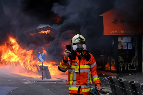 消防士は 年金改革法と社会正義のための動員の日である5月の日の労働行進の間に建物内の火災を消火しようとします フランス5月1 2023 — ストック写真
