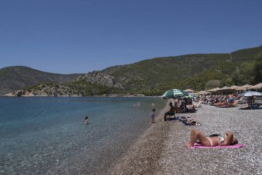 17 Ağustos 2021 'de Atina' nın güneyindeki Alimos banliyösünde güneşlenen insanlar.