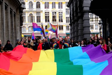Belçika 'nın başkenti Brüksel' de 10 Mayıs 2023 'te lezbiyen, eşcinsel, biseksüel ve transgender odaklı insanların bir tezahürü olan Belçika Gururu' nda insanlar büyük bir gökkuşağı bayrağı taşıyor..