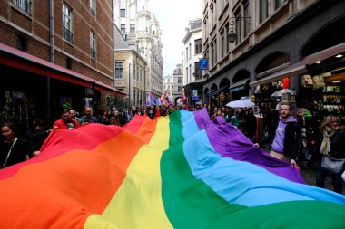 Belçika 'nın başkenti Brüksel' de 10 Mayıs 2023 'te lezbiyen, eşcinsel, biseksüel ve transgender odaklı insanların bir tezahürü olan Belçika Gururu' nda insanlar büyük bir gökkuşağı bayrağı taşıyor..