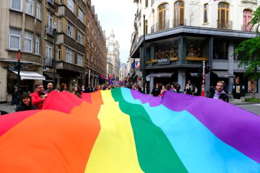 Belçika 'nın başkenti Brüksel' de 10 Mayıs 2023 'te lezbiyen, eşcinsel, biseksüel ve transgender odaklı insanların bir tezahürü olan Belçika Gururu' nda insanlar büyük bir gökkuşağı bayrağı taşıyor..