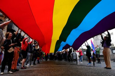 Belçika 'nın başkenti Brüksel' de 10 Mayıs 2023 'te lezbiyen, eşcinsel, biseksüel ve transgender odaklı insanların bir tezahürü olan Belçika Gururu' nda insanlar büyük bir gökkuşağı bayrağı taşıyor..