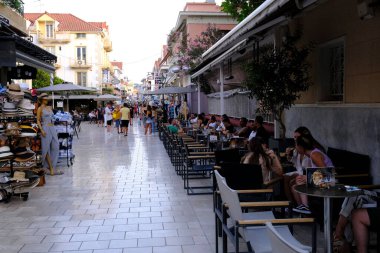 İnsanlar 27 Temmuz 2021 'de Yunanistan' ın Kefalonya adasındaki Argostoli kentinin pitoresk merkezinde yürüyorlar..