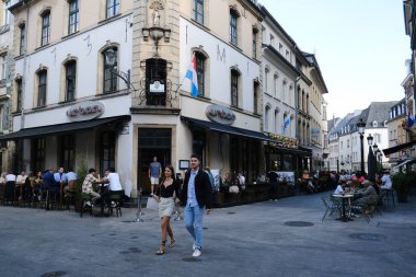 7 Haziran 2023 'te Lüksemburg' un merkezindeki güneşli bir günde insanlar bir kafenin terasında otururlar..