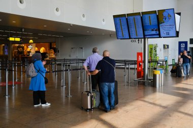 Yolcular 11 Haziran 2023 'te Brüksel, Belçika' daki Zaventem uluslararası havaalanındaki panoya bakıyorlar..