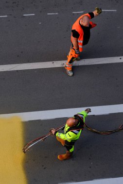 4 Temmuz 2023 'te Belçika' nın Brüksel kentindeki yaya geçidine boya spreyi kullanan bir belediye işçisi sarı yol işaretleri uyguladı..