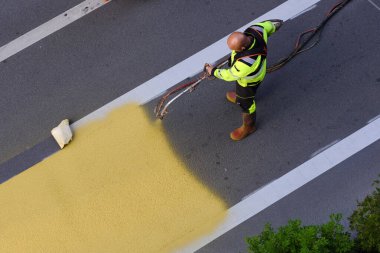 4 Temmuz 2023 'te Belçika' nın Brüksel kentindeki yaya geçidine boya spreyi kullanan bir belediye işçisi sarı yol işaretleri uyguladı..