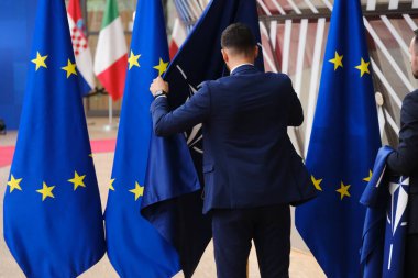 Belçika 'nın Brüksel kentindeki Avrupa Karargahında 29 Haziran 2023' te AB ve NATO bayraklarını düzelten bir yetkili görülüyor.