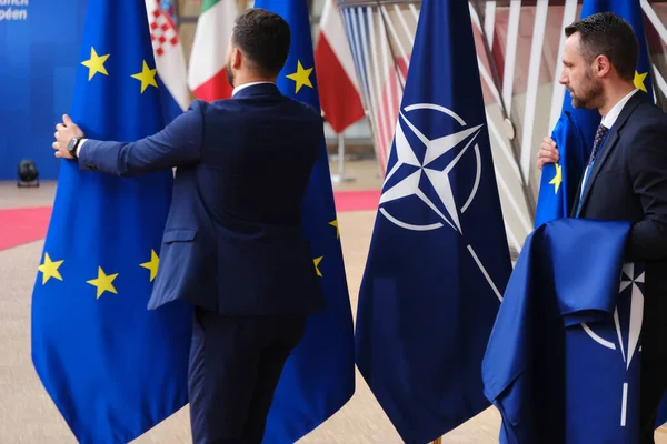 stock image An official adjusts EU and NATO flags in European Headquarters in Brussels, Belgium on June 29, 2023.