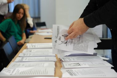 Belçika 'nın Brüksel kentindeki bir sandık merkezinde 24 Haziran 2023' te yapılacak Yunan parlamento seçimlerinde bir seçim görevlisi oy pusulalarını hazırlıyor.