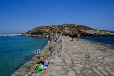 İnsanlar 10 Temmuz 2023 'te Yunanistan' ın Naxos limanında güneşlenip yüzüyorlar.