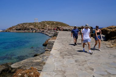 9 Temmuz 2023 'te Yunanistan' ın Naxos adasındaki Delian Apollo antik tapınağının kalıntıları önünde yürüyen insanlar görülüyor..
