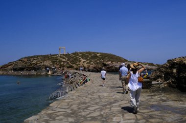 9 Temmuz 2023 'te Yunanistan' ın Naxos adasındaki Delian Apollo antik tapınağının kalıntıları önünde yürüyen insanlar görülüyor..