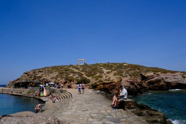 9 Temmuz 2023 'te Yunanistan' ın Naxos adasındaki Delian Apollo antik tapınağının kalıntıları önünde yürüyen insanlar görülüyor..