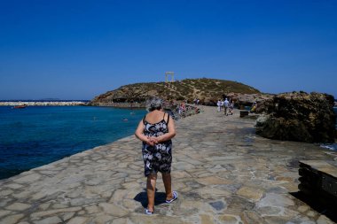 9 Temmuz 2023 'te Yunanistan' ın Naxos adasındaki Delian Apollo antik tapınağının kalıntıları önünde yürüyen insanlar görülüyor..