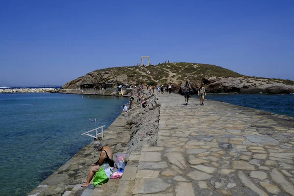 İnsanlar 10 Temmuz 2023 'te Yunanistan' ın Naxos limanında güneşlenip yüzüyorlar.