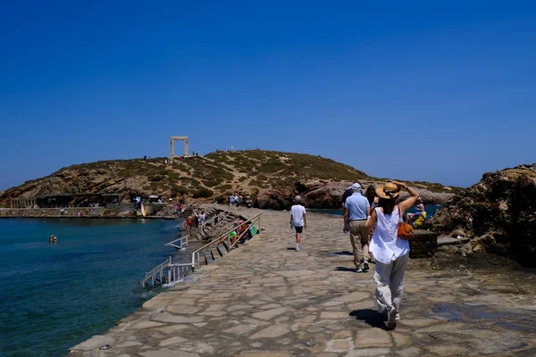 9 Temmuz 2023 'te Yunanistan' ın Naxos adasındaki Delian Apollo antik tapınağının kalıntıları önünde yürüyen insanlar görülüyor..