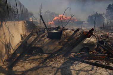 22 Ağustos 2023 'te Atina' nın banliyösünde çıkan yangında yanmış bir arabanın görüntüsü.