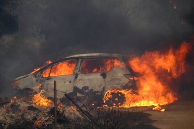 View of  a burnt out car during a wildfire in suburb of Athens, Greece August 22, 2023. clipart