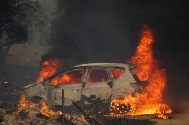 22 Ağustos 2023 'te Atina' nın banliyösünde çıkan yangında yanmış bir arabanın görüntüsü.