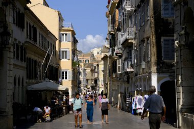 Turistler 1 Eylül 2023 'te Yunanistan' ın eski Corfu kentinde sıcak bir günde yürüyorlar.
