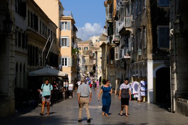 Turistler 1 Eylül 2023 'te Yunanistan' ın eski Corfu kentinde sıcak bir günde yürüyorlar.