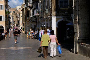 Turistler 1 Eylül 2023 'te Yunanistan' ın eski Corfu kentinde sıcak bir günde yürüyorlar.