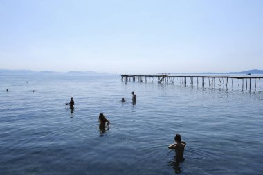 İnsanlar 2 Eylül 2023 'te Yunanistan' ın Korfu kentinde denizde yüzerken güneşli havanın tadını çıkarıyorlar.. 