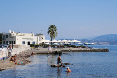 2 Eylül 2023 'te Yunanistan' ın Korfu kentindeki Mon Repos plajında şemsiyeler ve güneşlikler.