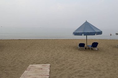 24 Ağustos 2023 'te Yunanistan' ın Kourouta plajında güneşli bir günde güneşlik ve şemsiyeler.