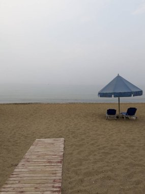 24 Ağustos 2023 'te Yunanistan' ın Kourouta plajında güneşli bir günde güneşlik ve şemsiyeler.