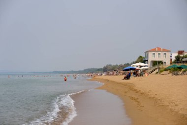 People enjoy the beach in Kourouta, Amaliada, Greece on August 24, 2023. clipart