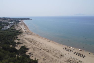 25 Ağustos 2023 'te Yunanistan' ın Kyllini kentinin kumlu plajındaki şemsiye ve otellerin hava manzarası