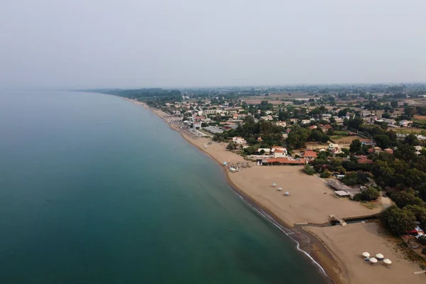 stock image Aerial view of sunbeds and umbrellas during a cloudy day in beach of Kourouta, Amaliada, Greece on August 24, 2023.