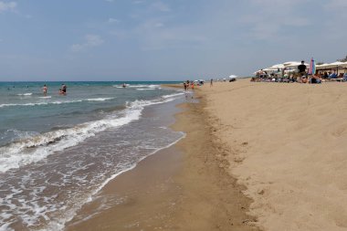 26 Ağustos 2023 'te Yunanistan' ın kumlu Zacharo plajında güneşlenirler.