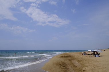 26 Ağustos 2023 'te Yunanistan' ın kumlu Zacharo plajında güneşlenirler.